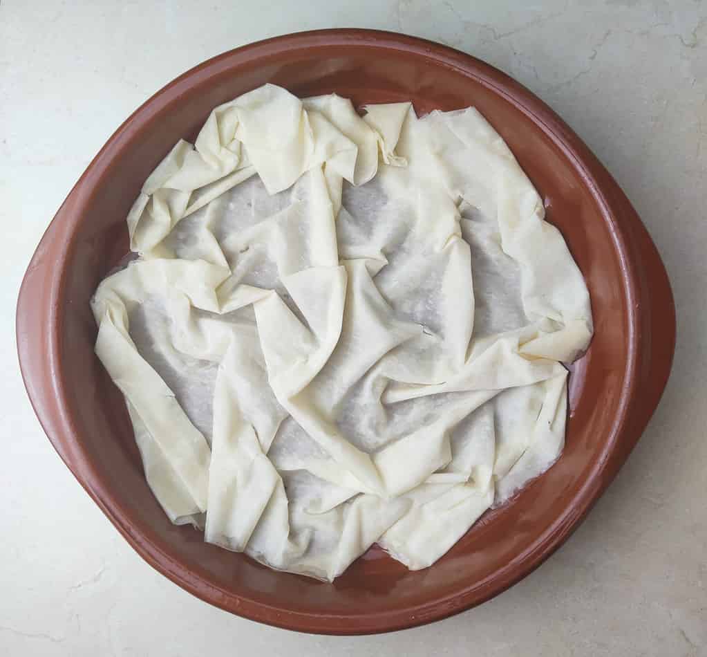 image showing how to place the phyllo sheet at the bottow of the pie pan